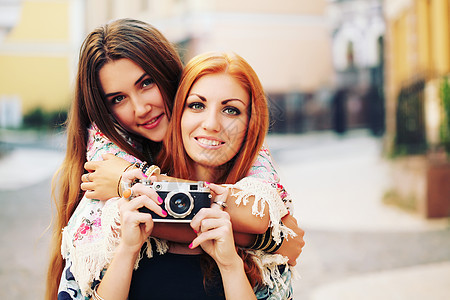两个女朋友着相机闲逛图片