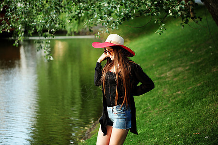 美丽的轻嬉皮士女孩户外享受大自然时尚的波霍时尚高加索女人穿着黑色开衫,帽子牛仔牛仔裤图片