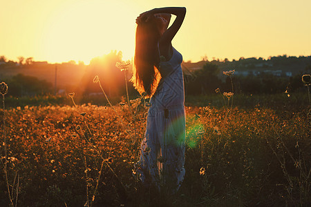 日落时田野里漂亮的轻女人照片色调风格Instagram过滤器图片
