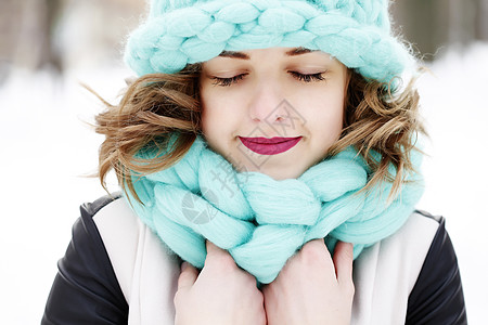 美丽的轻女人戴着美利奴羊毛色的帽子围巾,享受着户外清新的早晨护肤,唇部护理,冬季睫毛护理图片