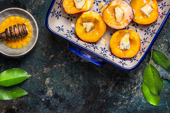 半桃子与奶酪蜂蜜烘焙盘黑暗的乡村背景,顶部视图烘焙桃子的准备图片