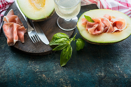 甜瓜与帕玛火腿黑暗的乡村厨房桌子上,放置文本意大利食品图片