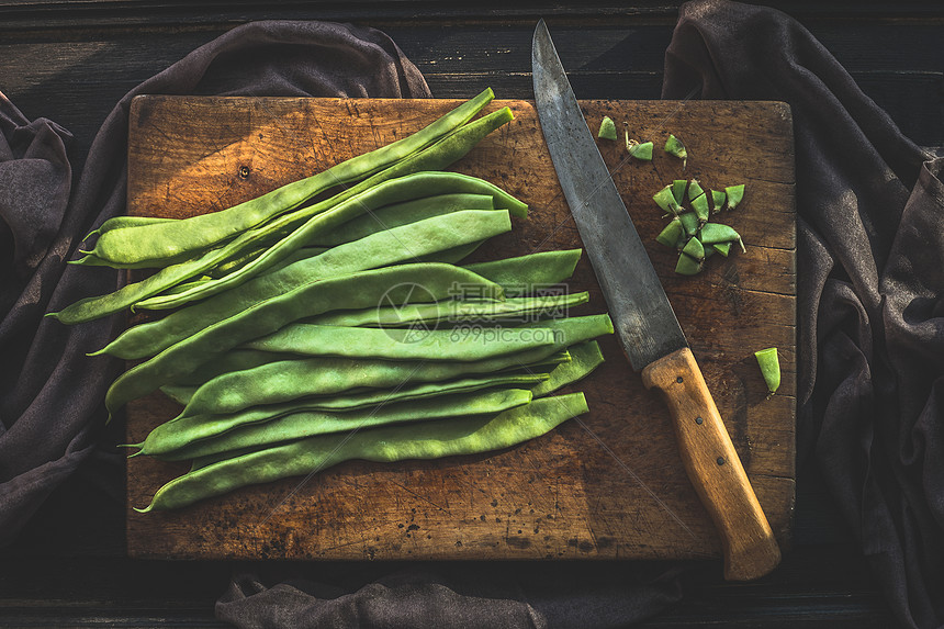 绿色法豆乡村切割板与菜刀深色木制背景,顶部视图豆类蔬菜图片