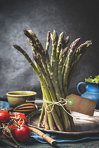 绿色芦笋与绳子空白标签黑暗的乡村厨房桌子上与烹饪原料图片