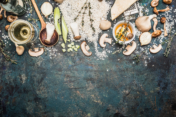 蘑菇饭配料与烹饪勺子黑暗的乡村背景,顶部视图,边界意大利食品图片
