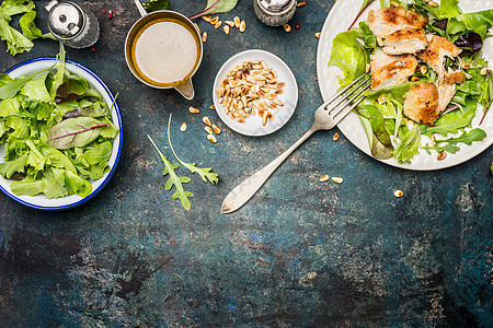 鸡肉沙拉与绿色混合沙拉叶,叉子敷料乡村背景,顶部视图,边界健康食品饮食饮食观念图片