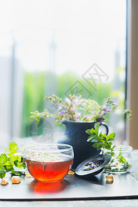 家庭场景与杯热草茶窗口自然背景,垂直健康饮料,排清洁食品的图片