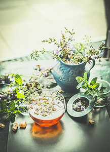 杯草药茶,茶工具新鲜草药植物露台花园桌子上健康饮料,排清洁食品的图片