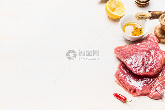 生金鱼肉配料烤架烹饪白色木制背景,地点为文字图片