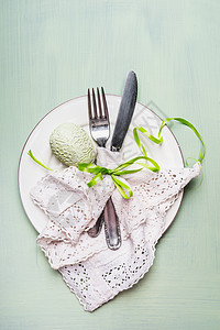 复活节餐桌与餐具鸡蛋装饰浅绿色背景,顶部视图图片