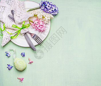 复活节餐桌与花鸡蛋浅绿色背景,顶部视图文字复活节餐的地点图片