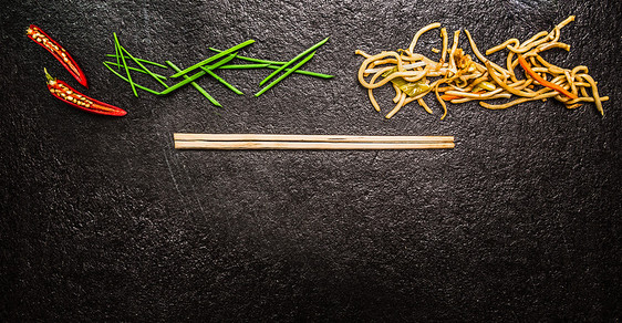 亚洲条与筷子,红辣椒,切碎的韭菜黑色石板背景,顶部视图,横幅网站图片