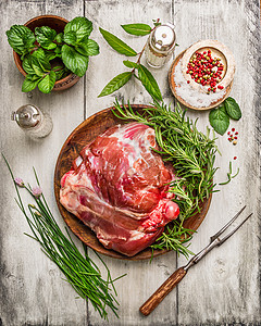 生腿羊肉与肉叉新鲜草药烹饪白色木制背景,顶部视图图片