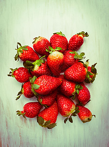 草莓堆木制背景上,顶部视图,色调图片