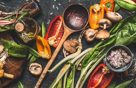 各种新鲜蔬菜与木制烹饪勺子健康饮食营养黑暗的乡村背景,顶部的图片