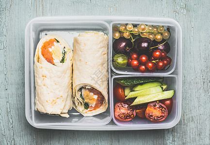健康的午餐盒与素食玉米饼包装,切碎的蔬菜水果木制背景,顶部视图图片