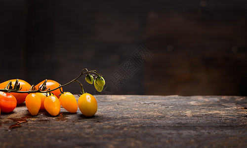 黄色西红柿枝乡村桌子上深色的木制背景上,健康的食物图片
