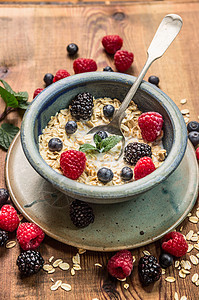 粥与牛奶,浆果乡村碗木制背景,健康的食物图片