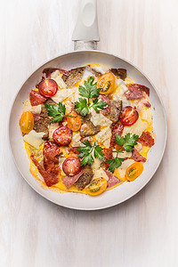 鸡蛋煎蛋卷白色煎锅与西红柿,包,奶酪香肠白色木制背景,顶部视图,图片