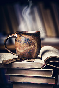 杯子与热饮料蒸汽堆开放的书籍图书馆图片