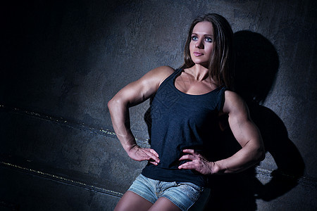 轻强壮的女健美运动员背景图片