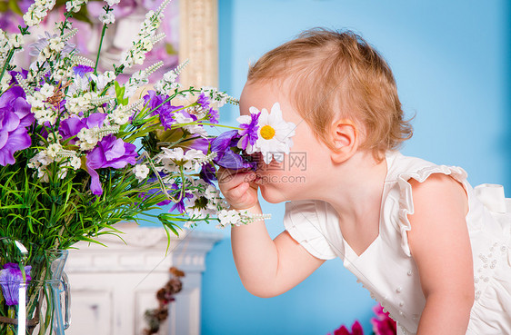 小女孩闻着朵花图片
