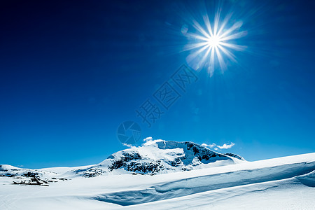 明亮太阳雪山上上的蓝天上背景