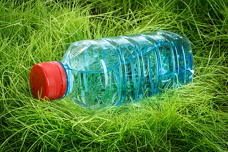 绿色草地上的瓶水图片