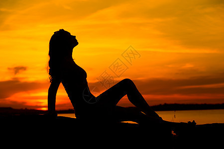 坐沙滩上的孕妇的剪影图片