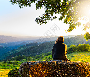 风景优美的妇女观看日落山,佩内达格雷斯公园,葡萄牙北部图片