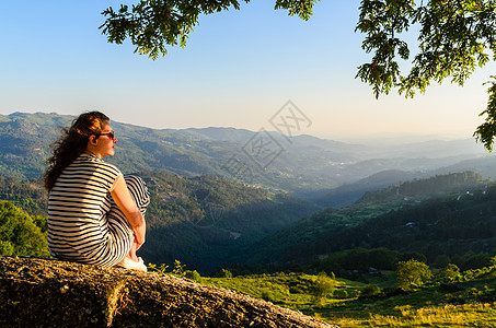 风景优美的妇女观看日落山,佩内达格雷斯公园,葡萄牙北部图片