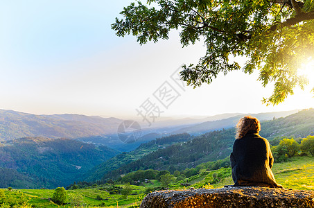 风景优美的妇女观看日落山,佩内达格雷斯公园,葡萄牙北部图片