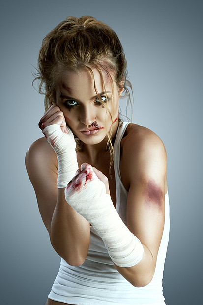 侵略的女战士身上瘀伤拳头上戴着的绷带站拳击防御位置准备中立的灰色