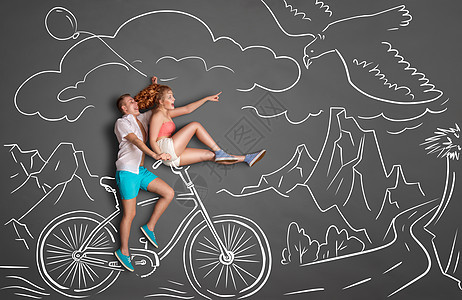 快乐情人节的爱情故事,浪漫的夫妇粉笔画背景的山脉男骑着女朋友骑自行车把手上,女指着只飞鹰图片