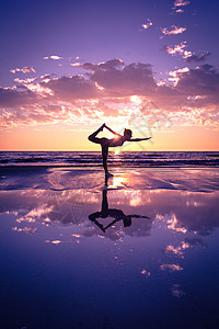 海滩瑜伽日落时海滩上练瑜伽的女人的剪影背景