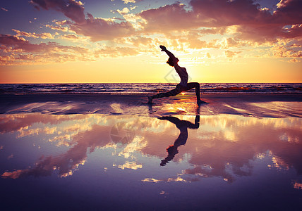 日落海滩上练瑜伽的女人剪影图片