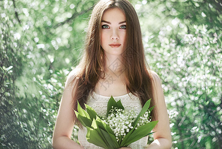 美丽的轻女子与百合花的山谷肖像关于自然的女孩春天的花朵时尚美图片