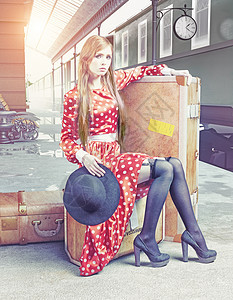 坐手提箱上的女孩复古火车站等着图片