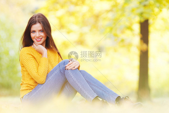 黑发女人坐秋天的公园里坐秋天公园里的位美丽的轻黑发女人的肖像图片