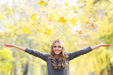 女人放下树叶女人秋天的公园里落叶图片