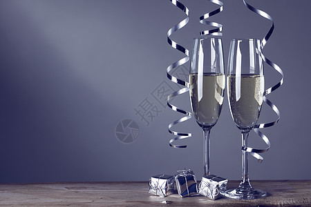 两个香槟杯两个香槟杯深色背景上的卷曲丝带图片