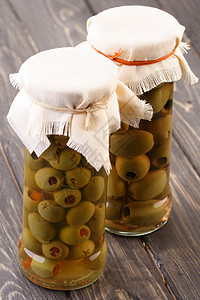 木桌上罐子里的腌制橄榄图片