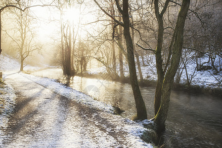 美丽的冬季雪覆盖着乡村的河流景观,充满了倒影图片