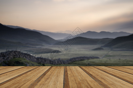 美丽的薄雾山日出景观与农场墙通向远方沿乡村田野向雾蒙蒙的斯诺登尼亚山脉眺望,远处木制的木板地板图片