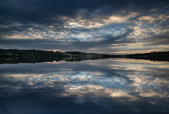 英国乡村夏天平静的湖上戏剧的日落图片