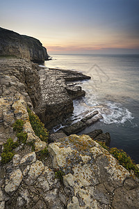 令人惊叹的海岸景观,长时间的曝光波日出时撞击岩石图片