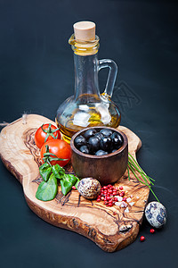 木制桌子上瓶油的黑色橄榄背景图片