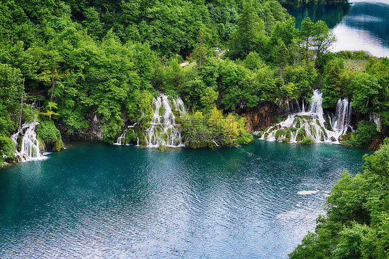 风景如画的湖森林里,高山上瀑布图片