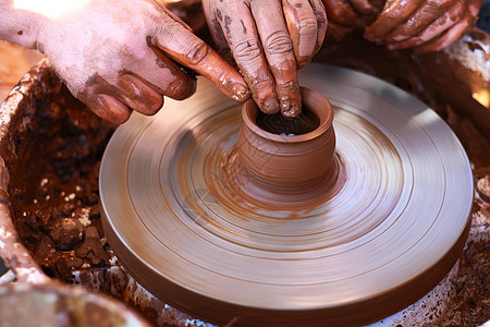陶轮上用粘土工作的手图片