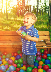快乐的孩子五颜六色的塑料球操场上玩,视野开阔图片